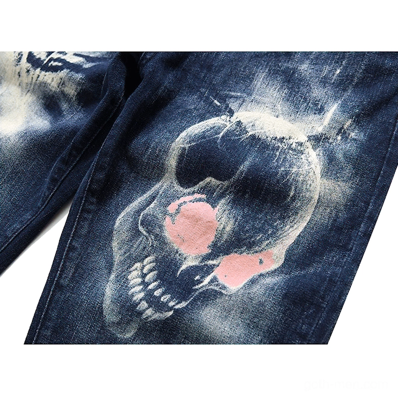 Close-up of printed skull and ghost hand texture on bleached blue denim fabric