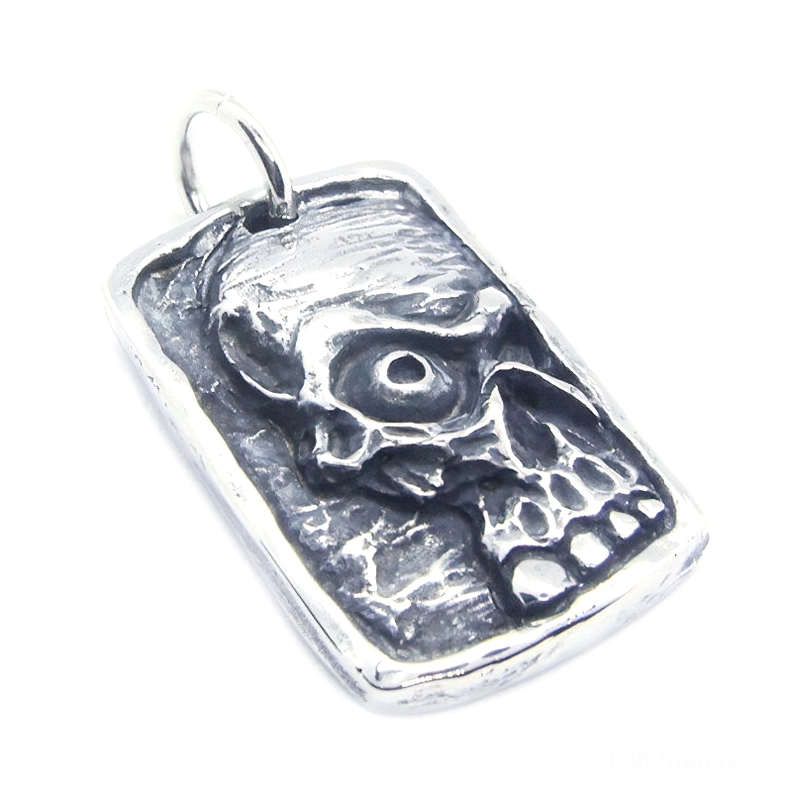 Front oblique view of embossed ghost skull dog tag pendant in matte silver stainless steel with textured details on white background