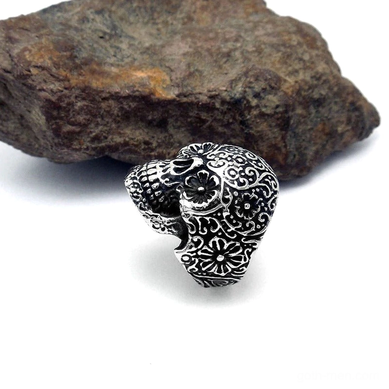 Low angle side view of gothic skull ring showing carved skull details and antique silver finish