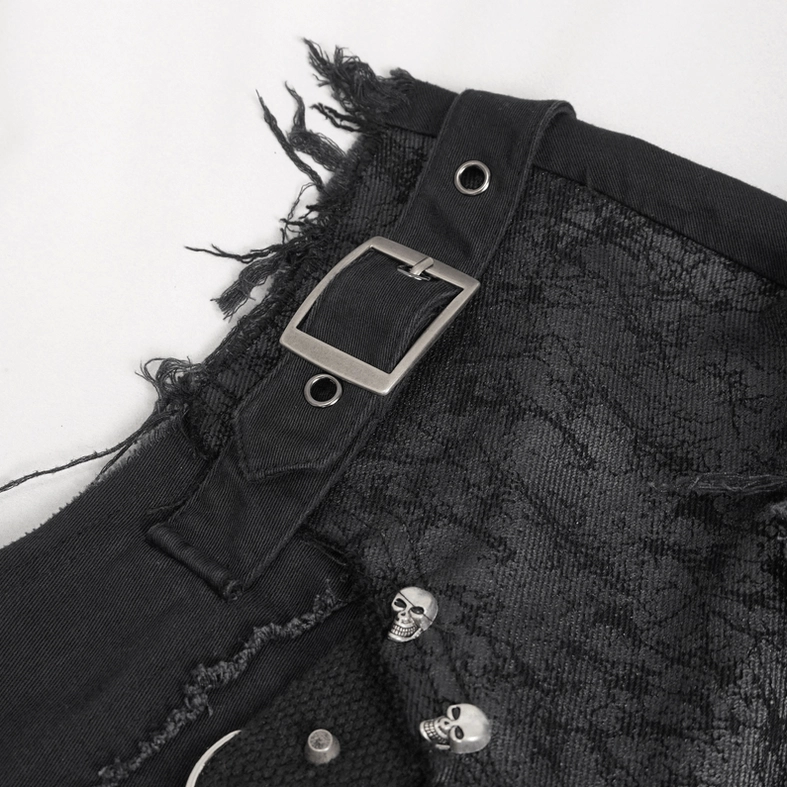 Close-up detail of gothic sleeveless shirt showing skull metal ornaments, leather strap buckle, and lace textured fabric