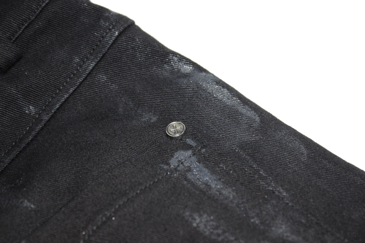 Side profile view of black slim-fit gothic trousers showing tapered leg and paint texture detail