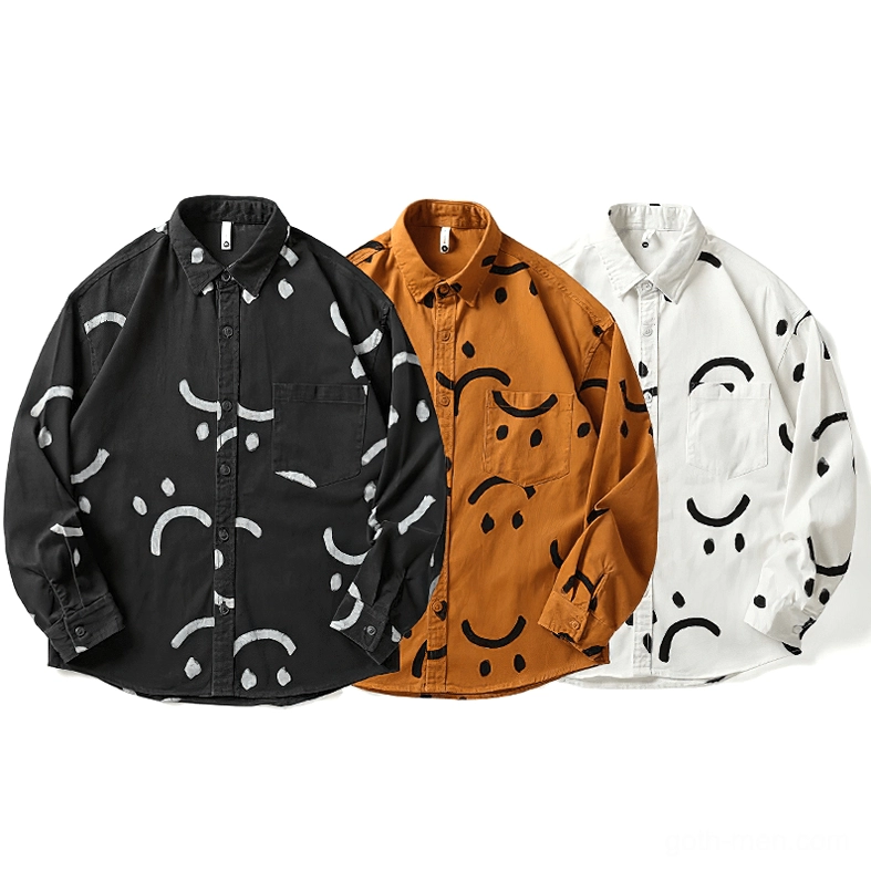 Three color variants of gothic smiley print cotton shirts laid flat, white black and burnt orange bases with contrasting smiley prints, button-down collar and chest pocket details