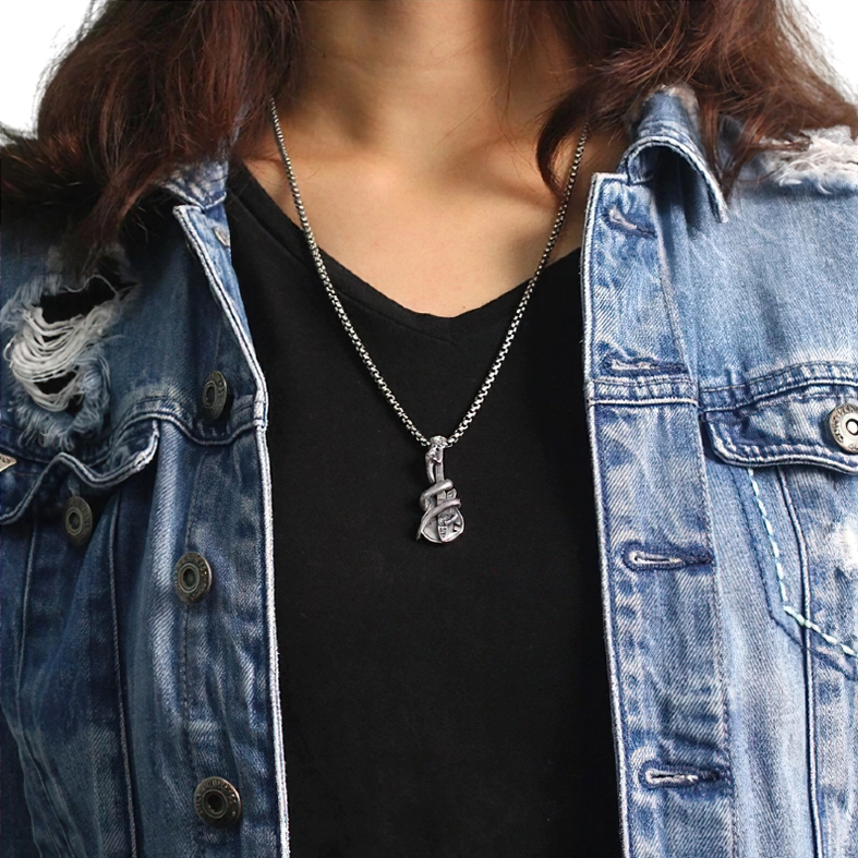 Female model wearing unisex gothic rock snake guitar pendant with ripped denim jacket