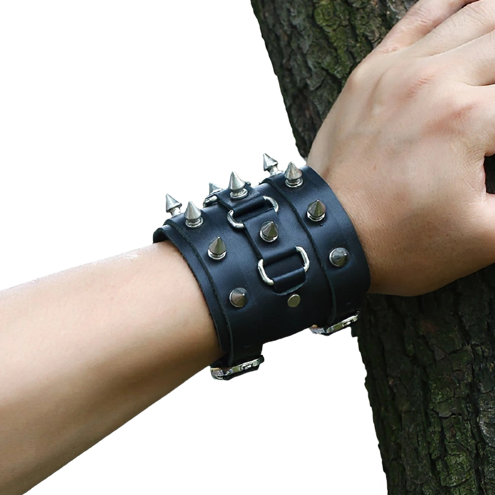 Gothic spiked leather cuff bracelet worn on wrist, close-up showing punk aesthetic styling with outdoor natural background