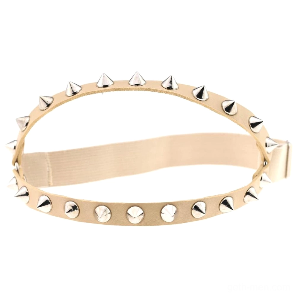 Beige nude-tone spiked knee garter with silver metal stud details and elastic adjustable strap, studio photography