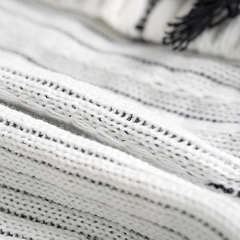 Off-white knit fabric texture showing neat woven stitch pattern and thick knit construction - yarn detail