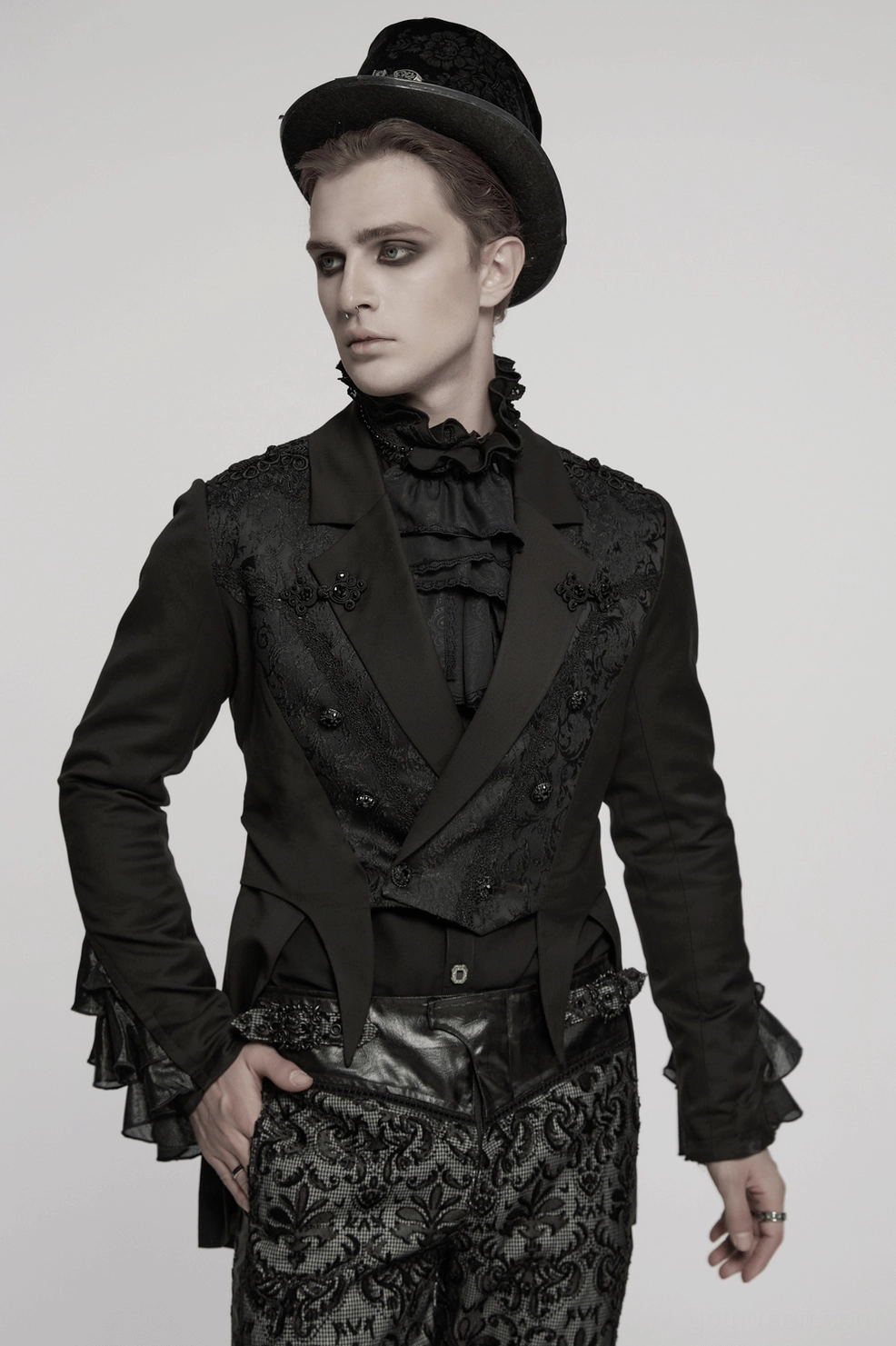 Victorian gothic men's tailcoat demonstrating theatrical drape, asymmetrical hemline, and embroidered sleeve detail on model