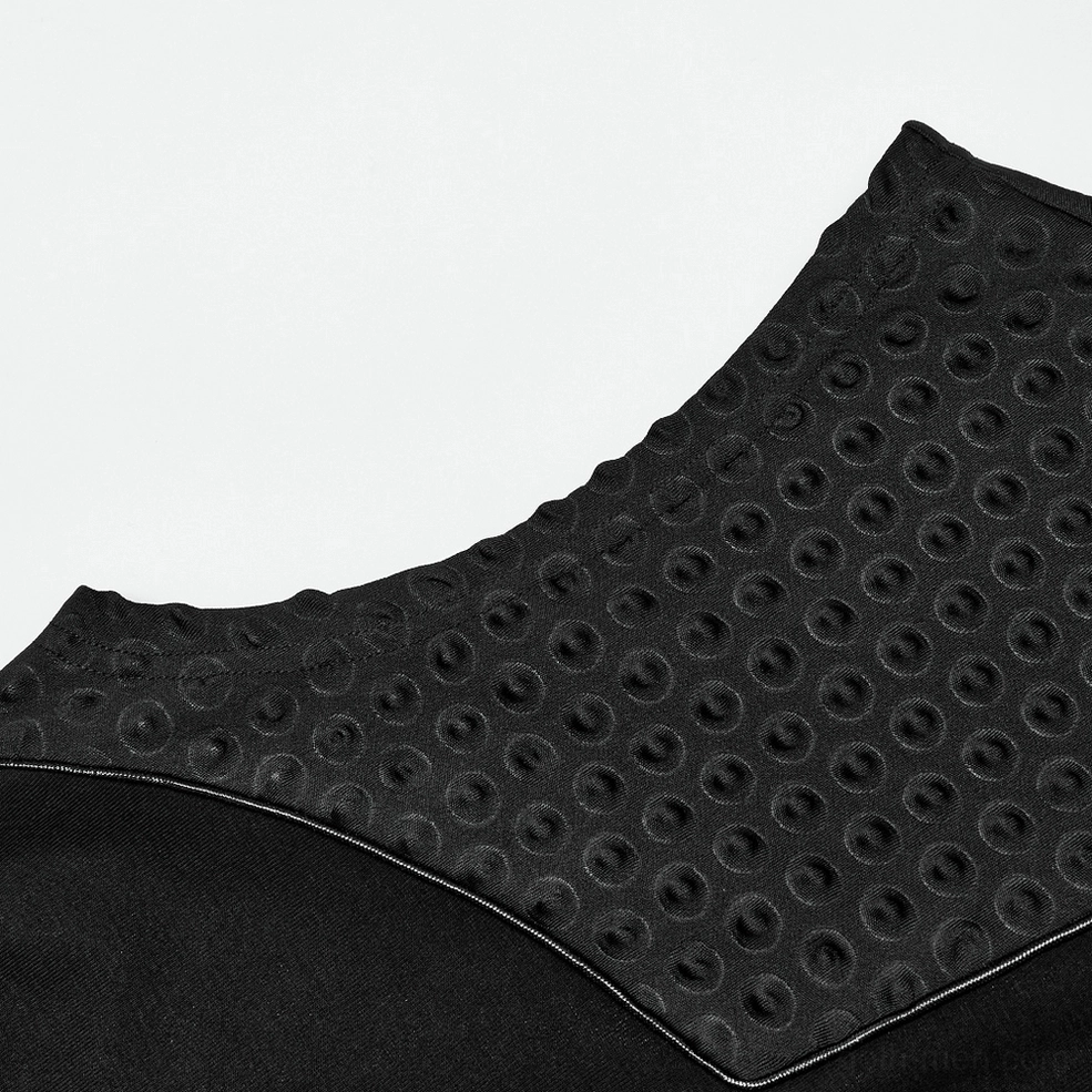 Close-up macro detail of 3D embossed circular texture pattern on black gothic tank top fabric