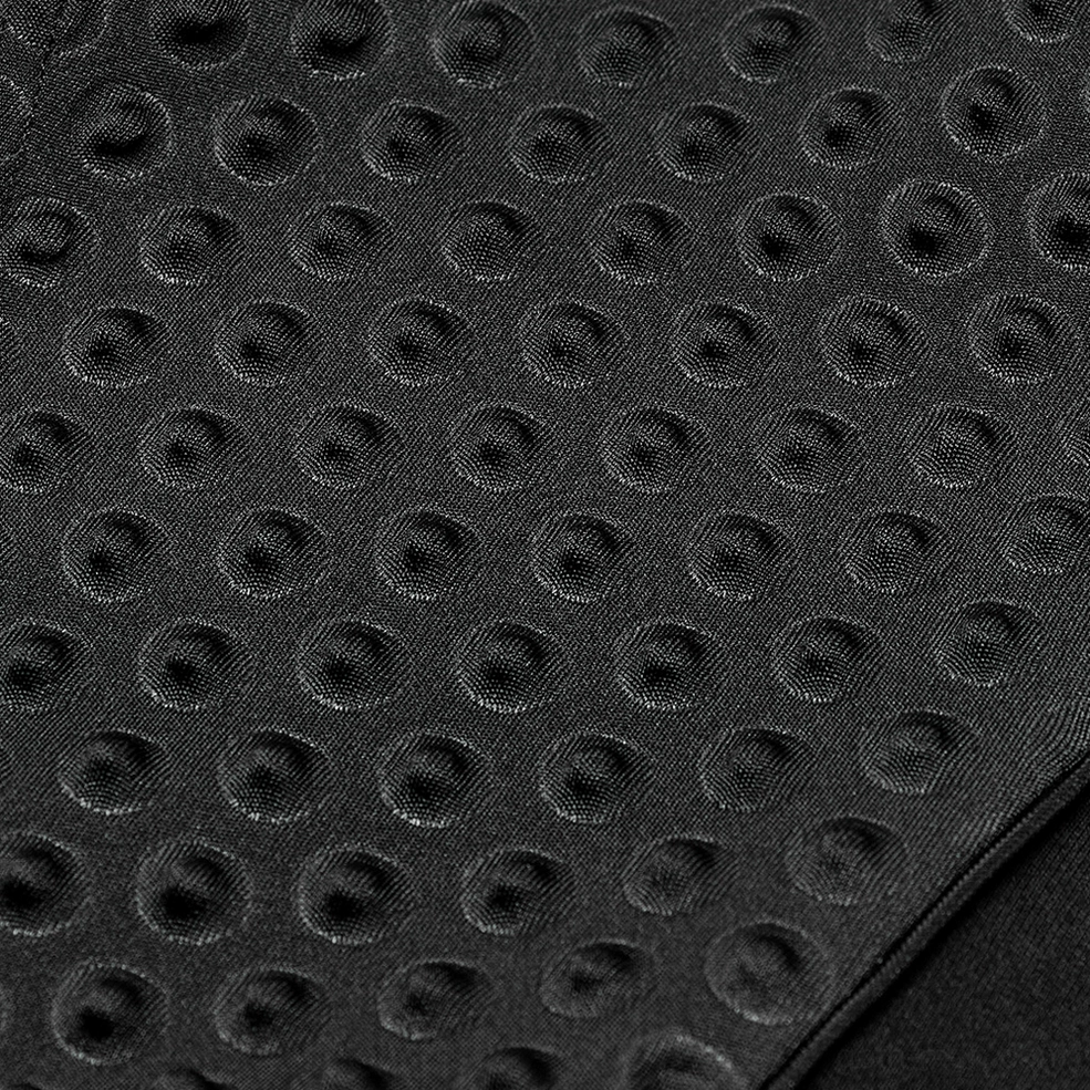 Macro photography of uniform circular embossed pattern on gothic sleeveless tank top fabric surface