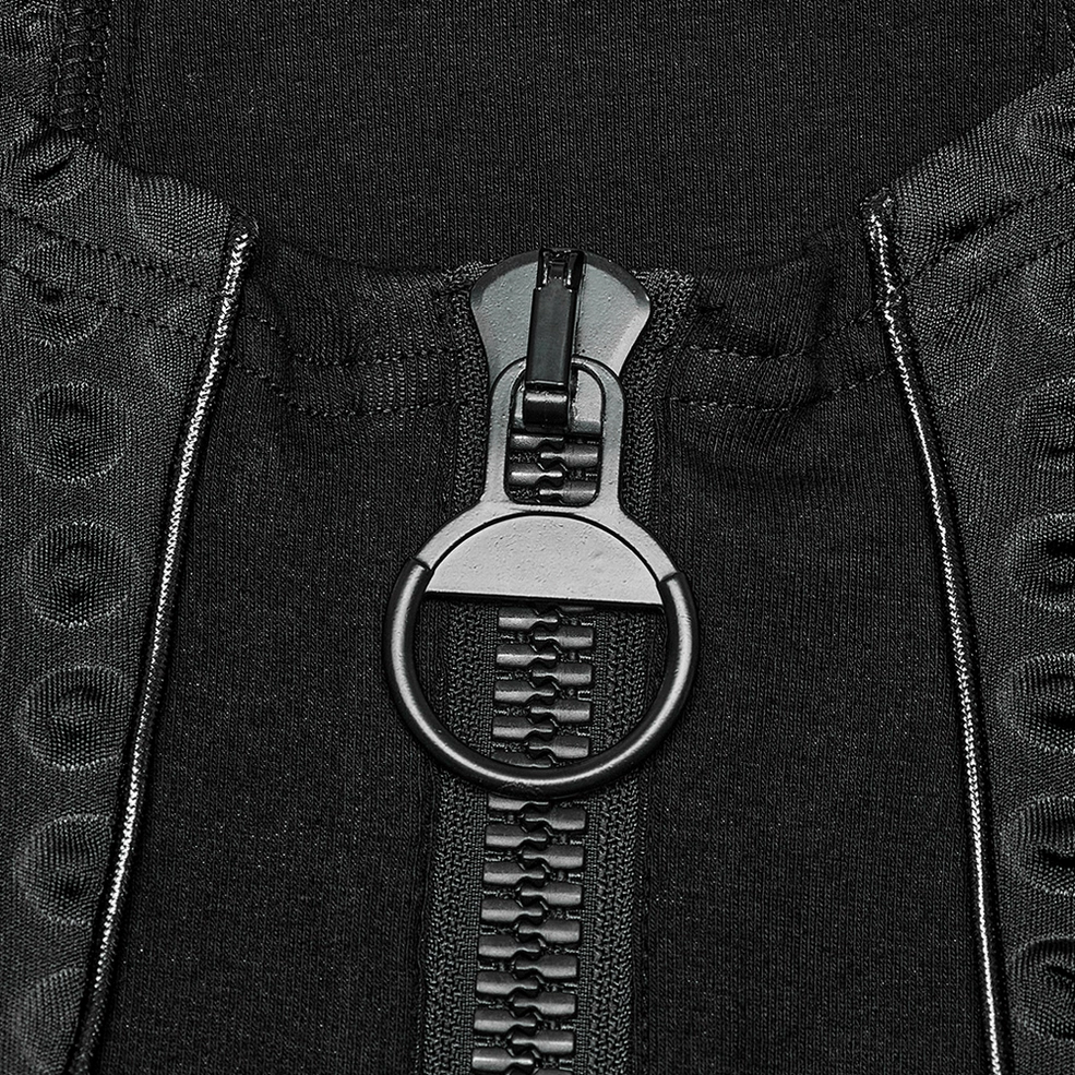Detailed front view of chunky metal zipper hardware with large ring pull on industrial gothic top