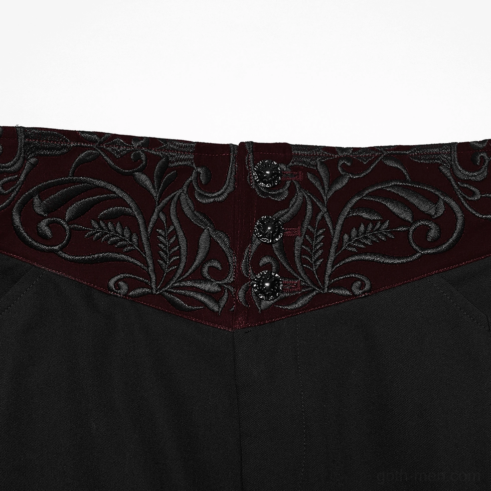 Close-up detail of embroidered wine-red velvet waistband with decorative buttons on gothic trousers