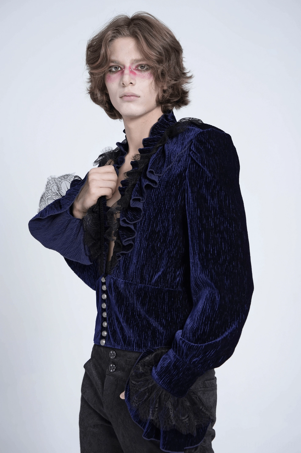 Styled shot of navy velvet gothic ruffled shirt layered with alternative fashion accessories on male model