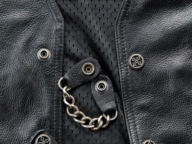 Black leather vest hardware close-up showing metal chain and snap button details