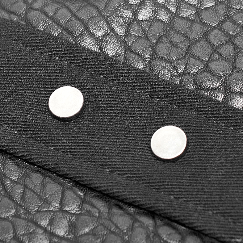 Close-up macro detail of metal rivets and textured faux leather on gothic armor vest