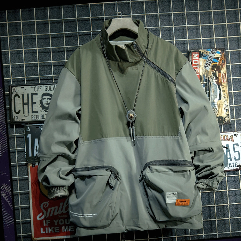 Two-tone green gothic patchwork jacket on wooden hanger with diagonal zipper and front cargo pockets