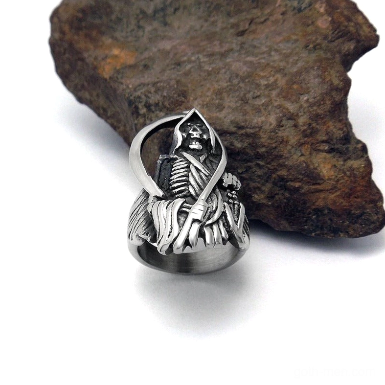 Grim Reaper gothic skull ring oblique view matte stainless steel aged silver patina leaning against rock