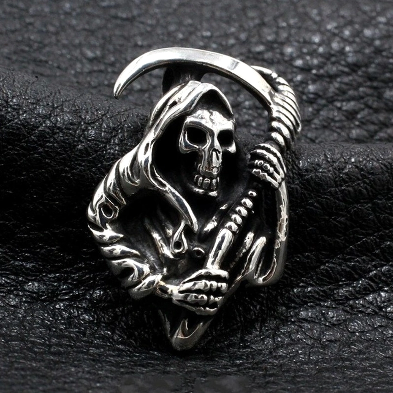 Antique silver Grim Reaper skeleton pendant close-up front view, carved gothic details and aged finish on leather texture background