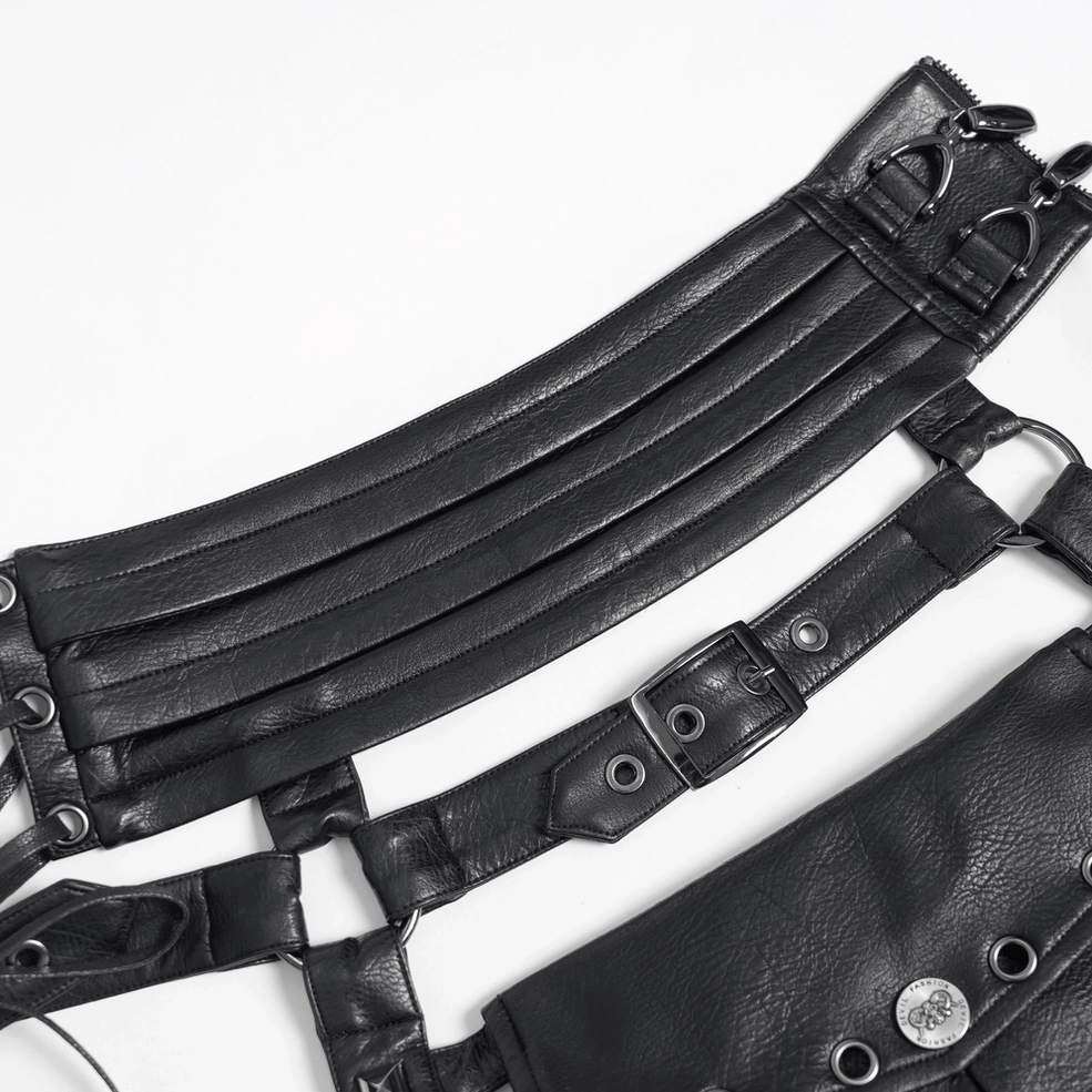 Close-up flat lay of black leather harness strap showing multi-layer construction, adjustable buckle, and metal reinforcement details
