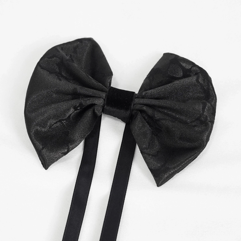 Three-quarter flat lay of black jacquard gothic bow tie displaying texture, velvet knot and long ties