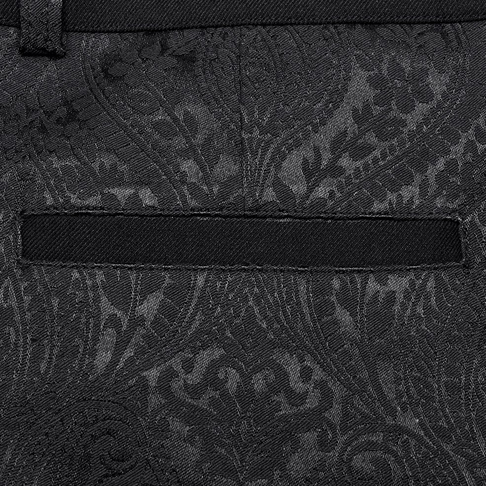 Texture close-up of paisley jacquard weave and front pocket on gothic slim-fit trousers