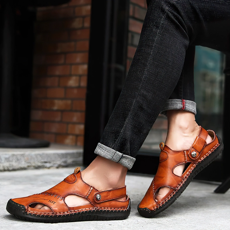 Male model wearing khaki tan leather gothic sandals with adjustable back strap in cafe outdoor setting