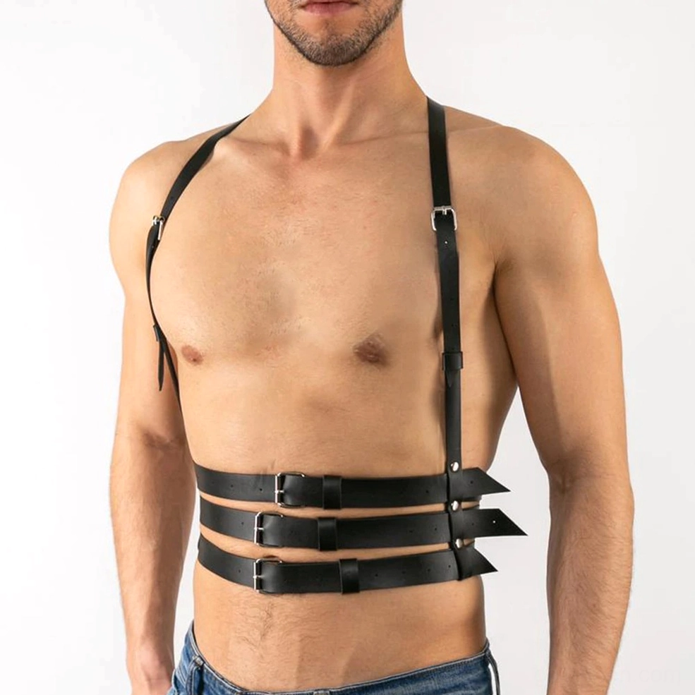 Asymmetrical single shoulder leather harness strap detail showing gothic-inspired industrial design and silver buckle accents