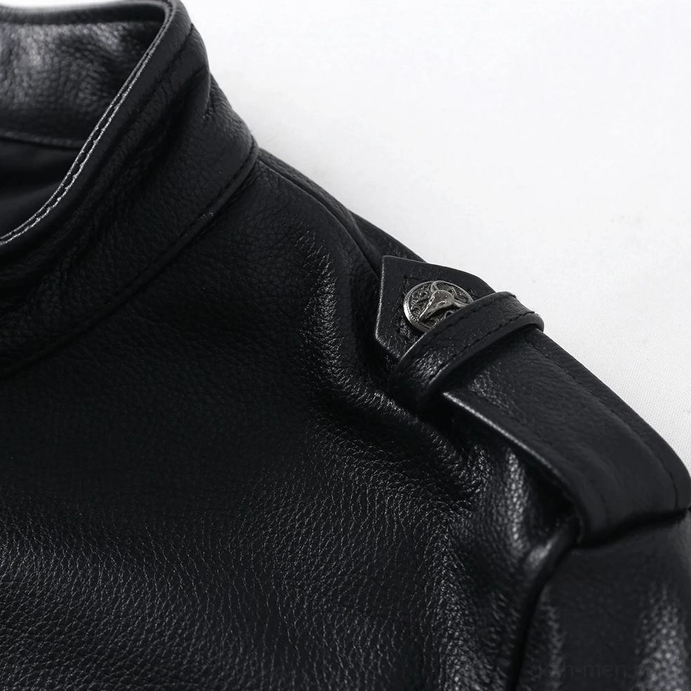 Close-up detail of genuine pebbled leather texture and metal shoulder strap button on gothic jacket