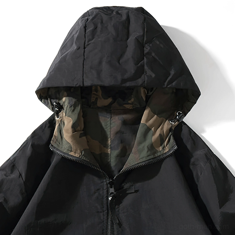 Man in oversized black gothic pullover hoodie front detail showing hood and half-zip feature
