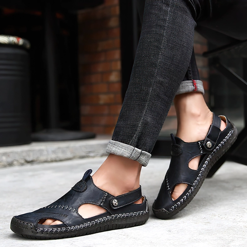 Men wearing black leather gothic sandals with rolled jeans on urban street, lifestyle low-angle shot