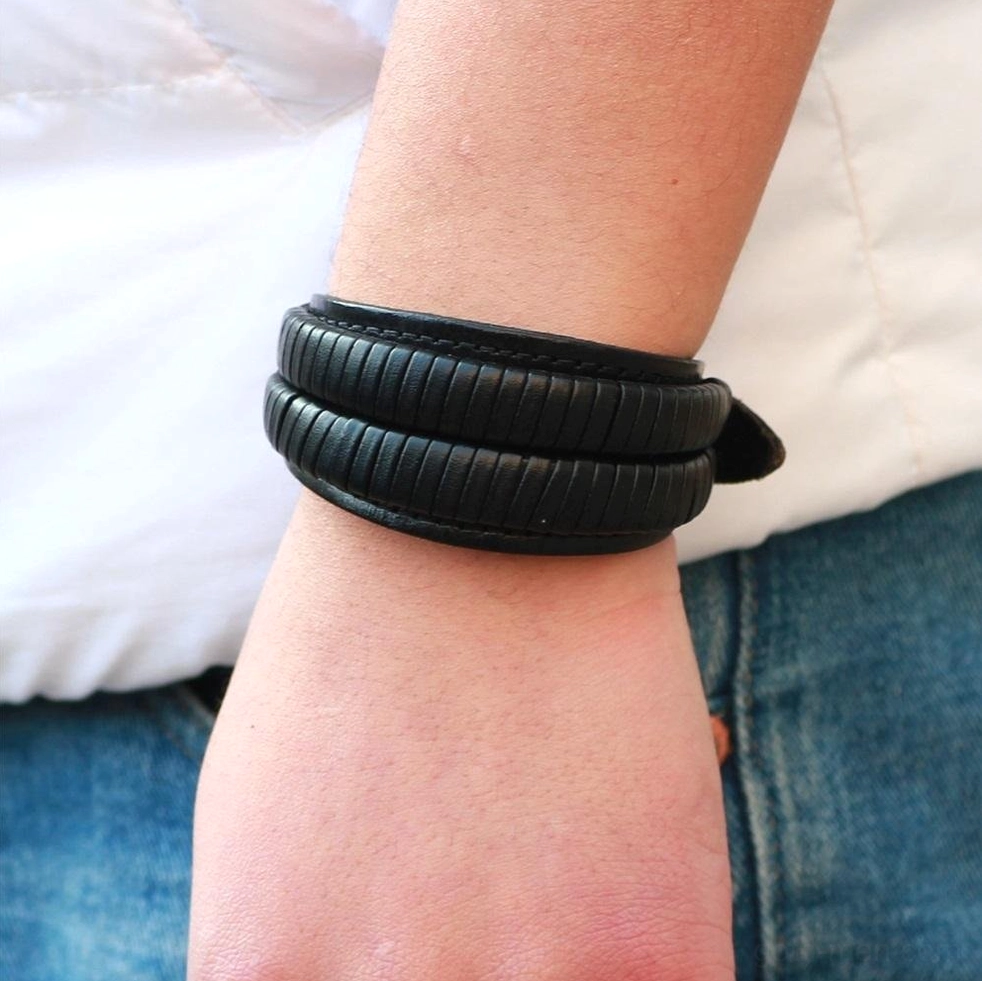 Double-wide men's leather cuff bracelet detail shot showing botanical embossing, metal hardware, gothic jewelry craftsmanship