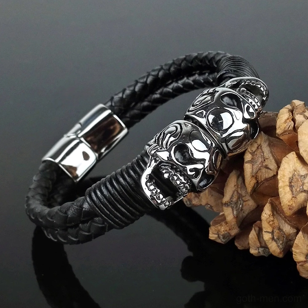 Angled view of braided skull bracelet with stainless steel skull charms and natural backdrop
