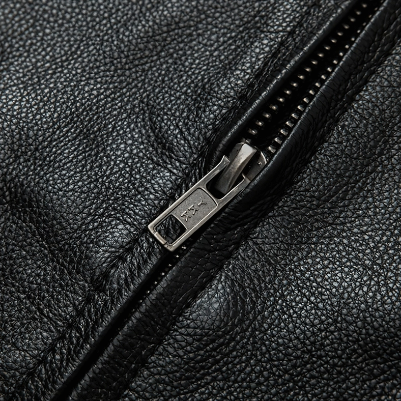 Metal zipper hardware close-up with branded pull tab on black leather gothic jacket