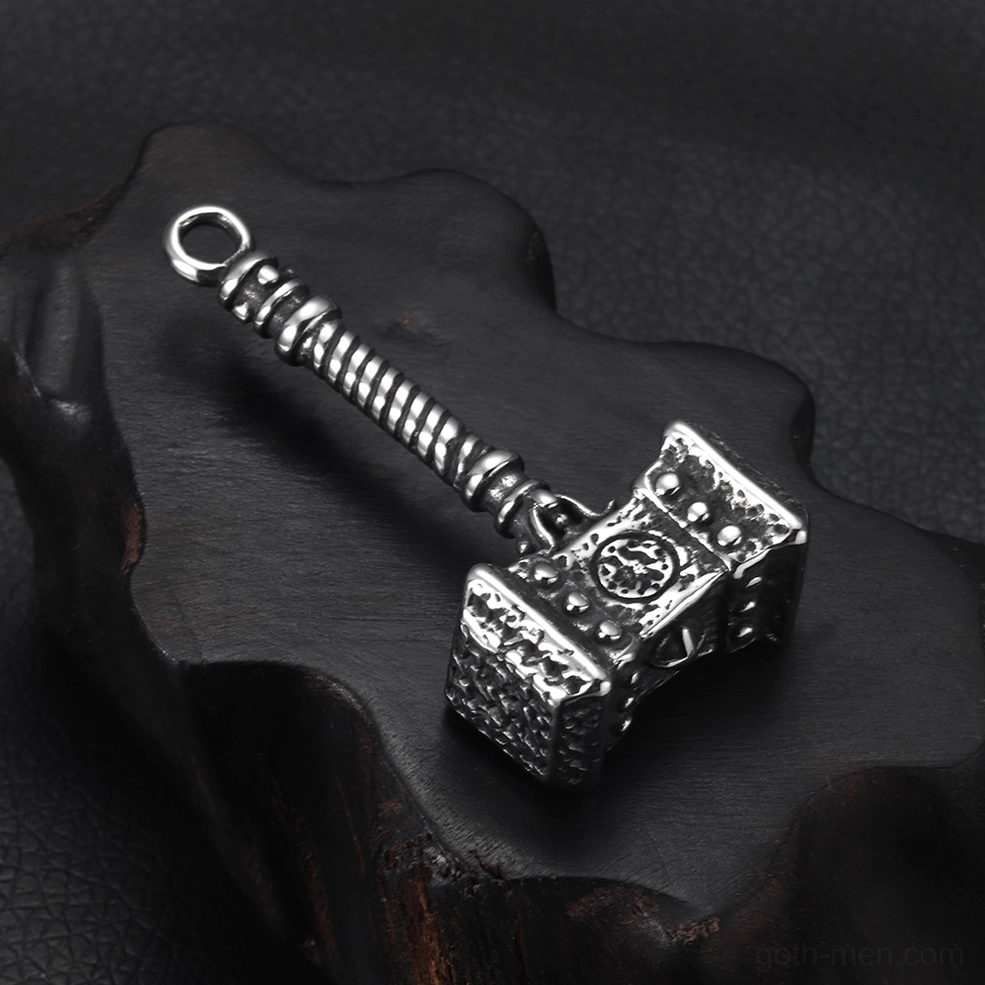 Mjolnir Viking gothic pendant - right oblique side view on textured leather and wooden display surface, vintage stainless steel finish