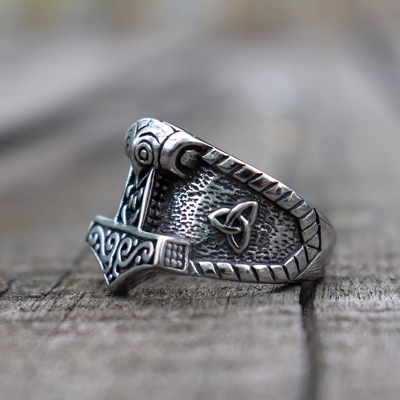 Mjolnir Celtic ring side angle showing detailed Nordic scroll engravings and vintage silver patina on stainless steel