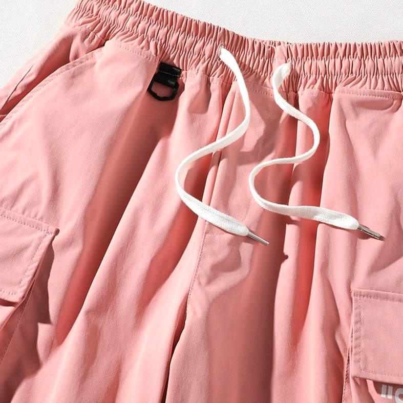 Close-up texture detail of pink cargo shorts waistband and fabric composition