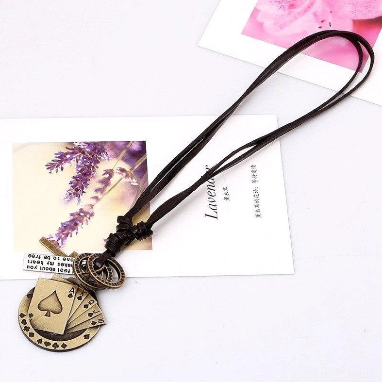 Brown leather cord poker card cross necklace with antique gold pendant flat lay styling