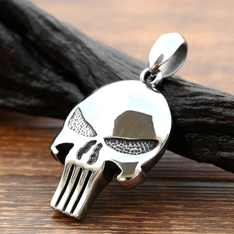 Punisher skull pendant styled display - polished silver metal with textured details on wooden surface, gothic fashion accessory