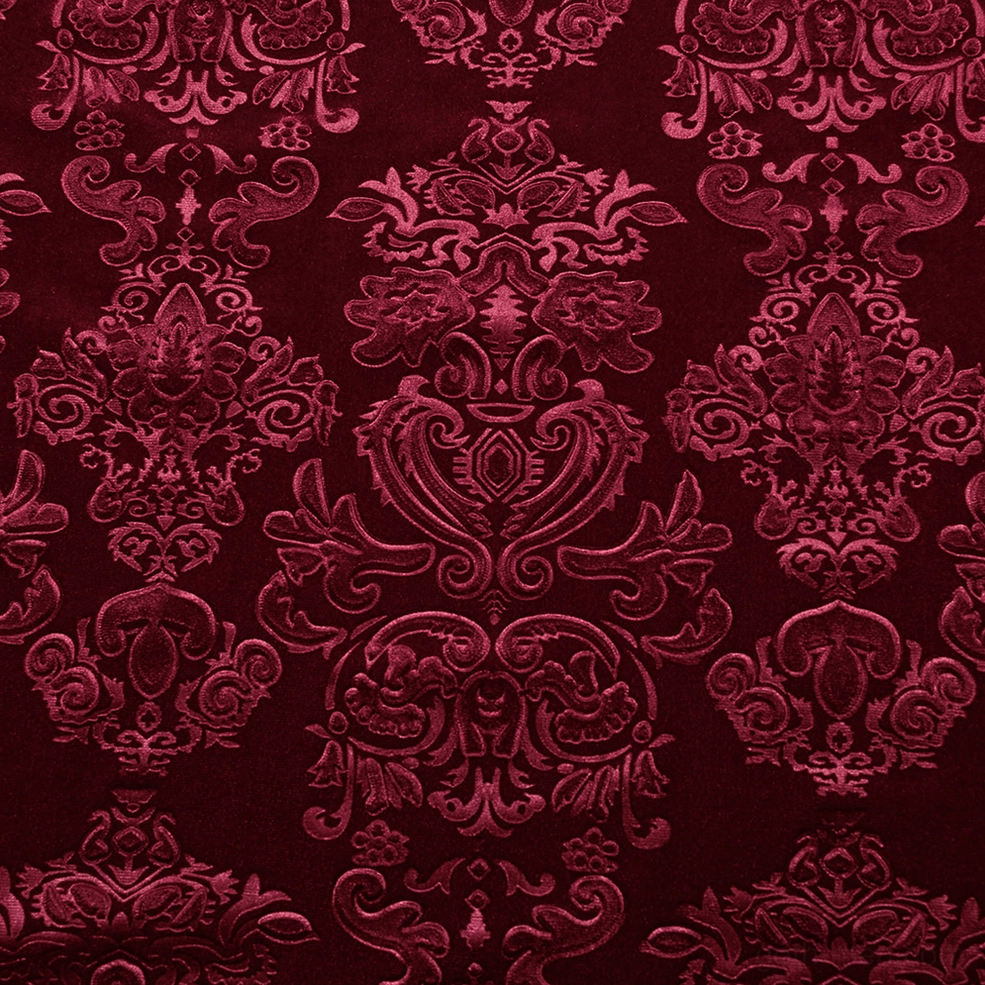 Macro close-up view of red velvet gothic shirt showing rich baroque damask floral embossed textile surface detail