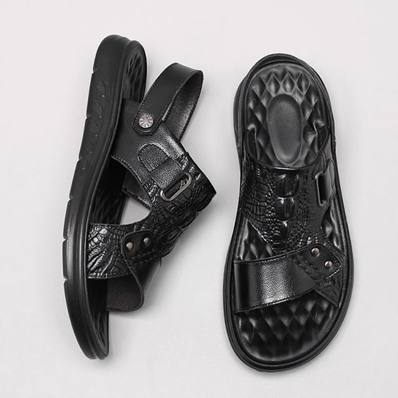 Black leather sandals overhead view detail shot showing non-slip TPU outsole and quilted insole construction