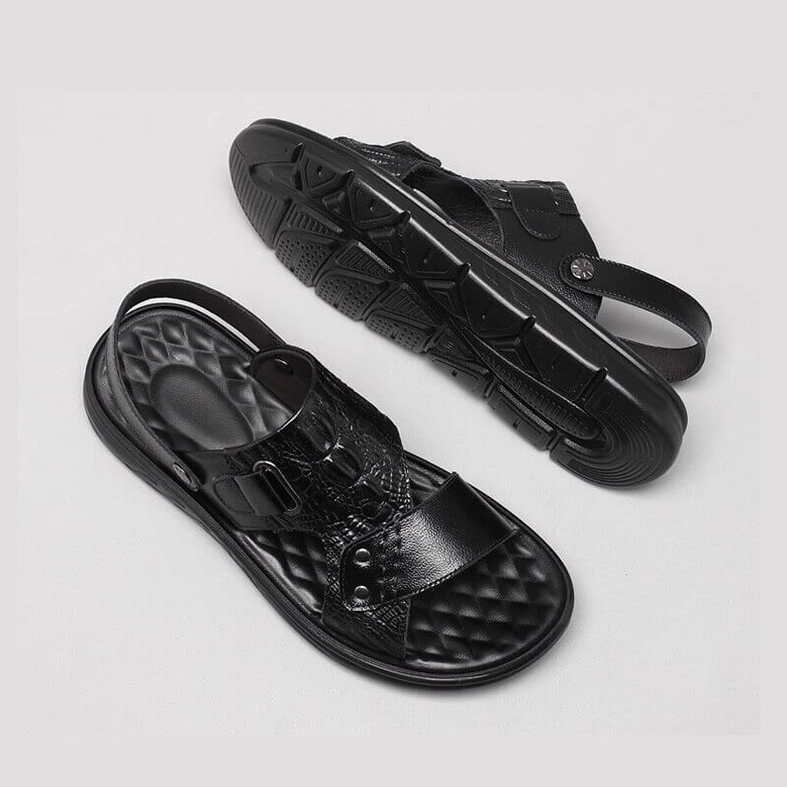Black genuine leather sandals overhead flat lay view featuring treaded outsole and adjustable buckle strap mechanism