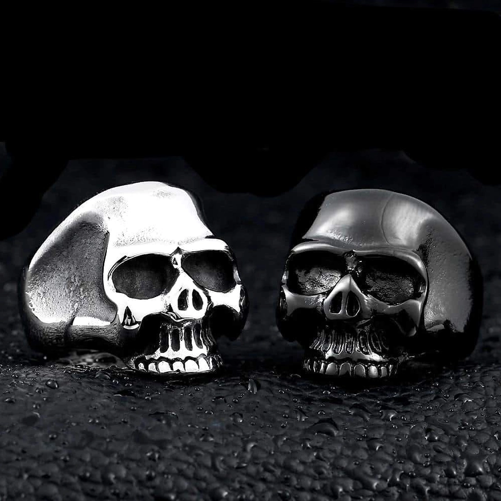Mixed color skull rings comparison - silver and black stainless steel gothic signet rings displayed together front view