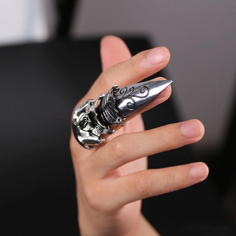 Silver gothic skull claw ring - side-worn close-up on dark background showing pointed nail cover and engravings