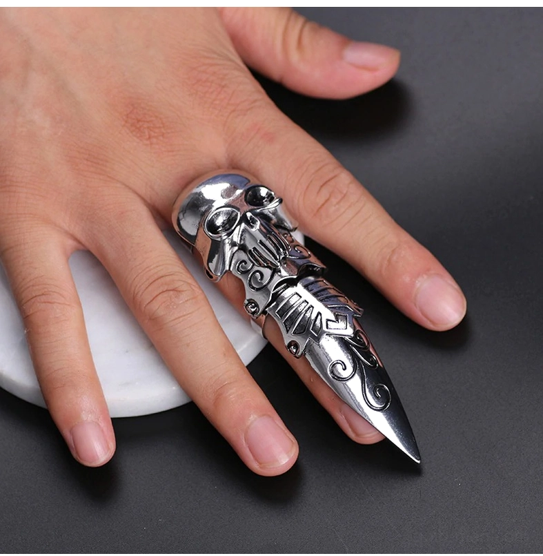 Silver gothic skull claw ring worn on finger - front close-up view displaying punk skull design details