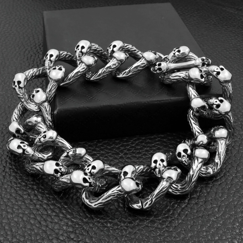 Vintage tone skull embellished chain bracelet overhead view on dark background showcasing dense skull accents and professional jewelry photography