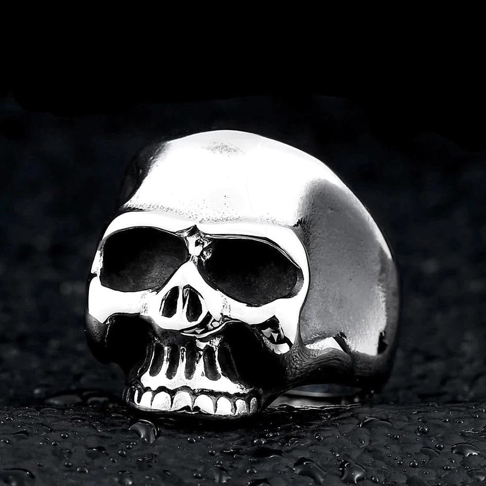 Silver polished skull signet ring front view showcasing anatomical skull structure and surgical-grade stainless steel finish on dark wet surface