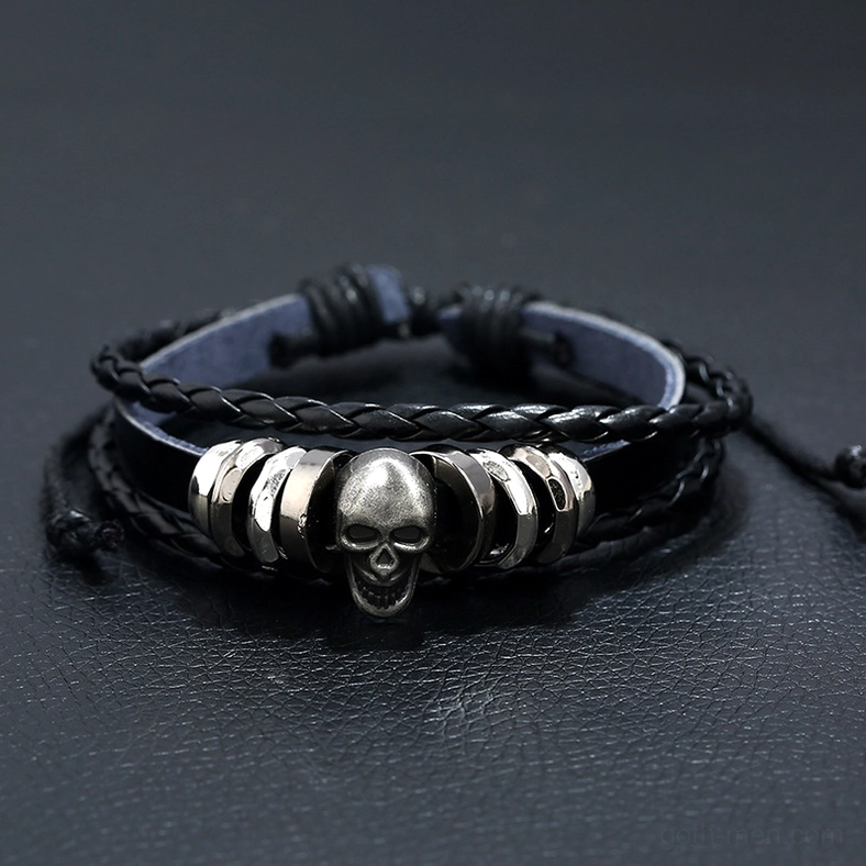 Front angled view of multi-layer leather skull bracelet displaying braided straps and silver alloy skull pendant with metal beads