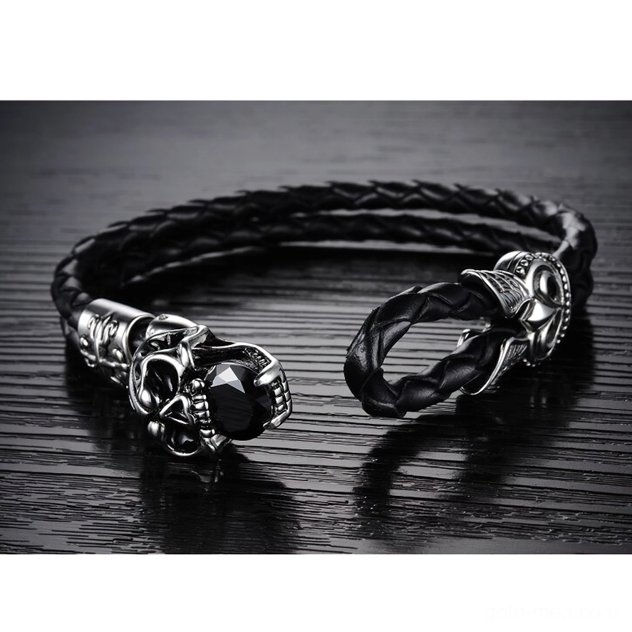 Unfastened gothic skull leather bracelet with hook clasp closure on dark wooden surface, flat lay product view