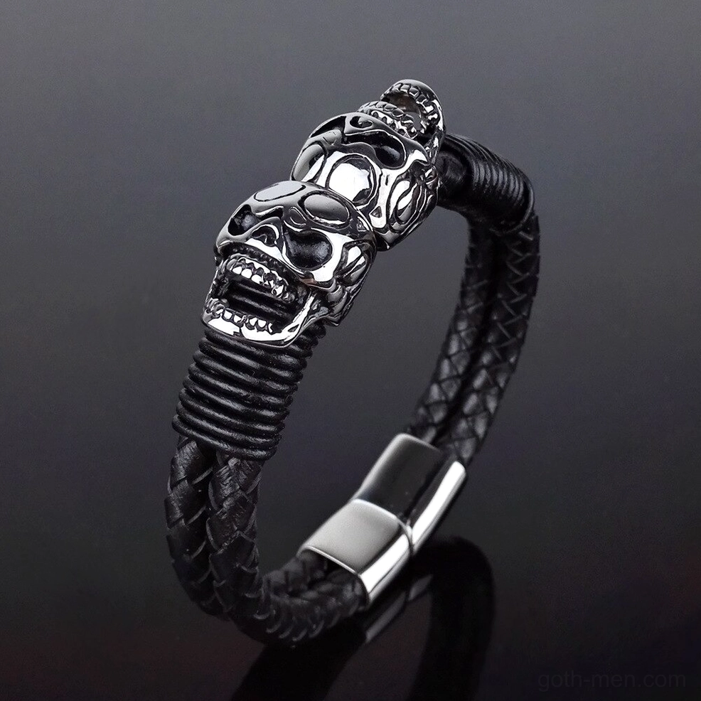 Stacked stainless steel skulls on braided black leather strap, vertical detail view