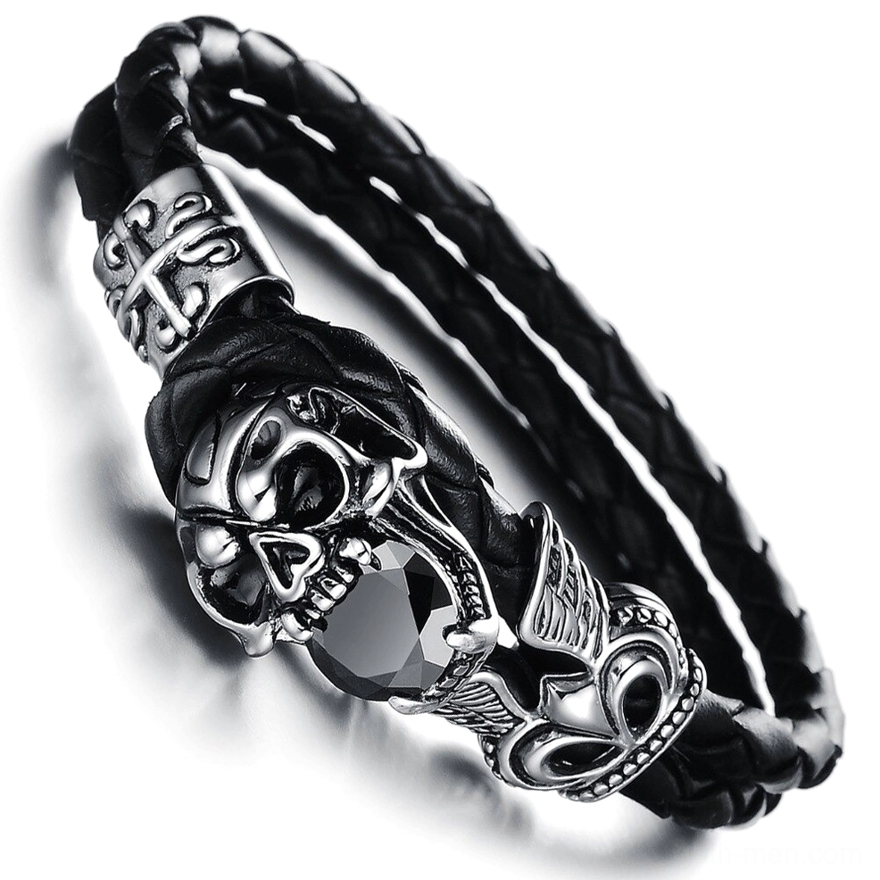 Close-up side view of winged skull charm bracelet showing detailed stainless steel craftsmanship and braided leather construction