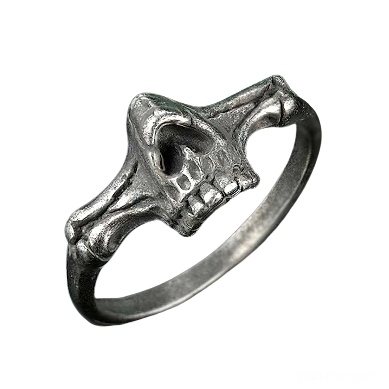 Three-quarter angle of dark metal skull ring displaying bone cross band design and exposed tooth details